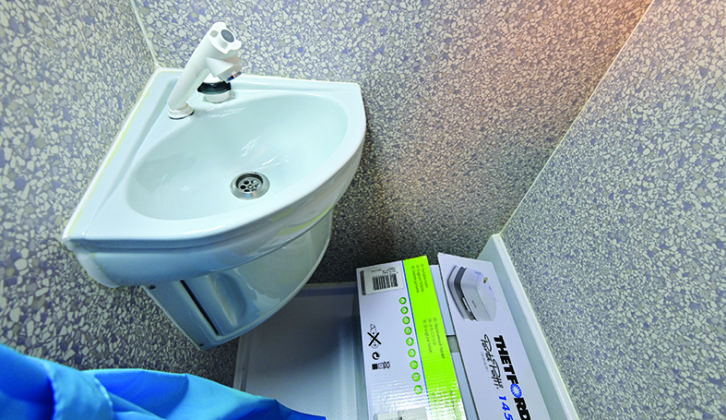 Basic washroom provides handbasin, small cupboard and Thetford Porta Potti
