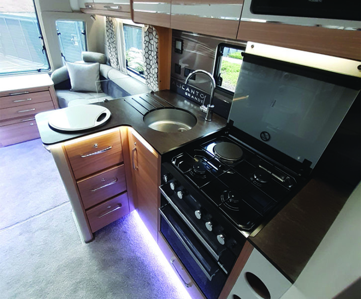 Well-equipped kitchen houses a microwave up above and a four-bottle wine rack below