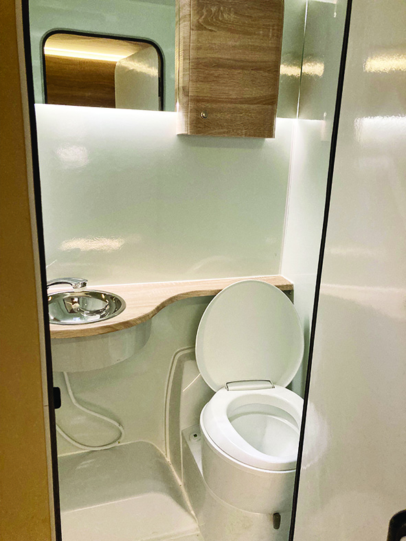 Small but functional washroom has an extendable tap and an acrylic shower tray