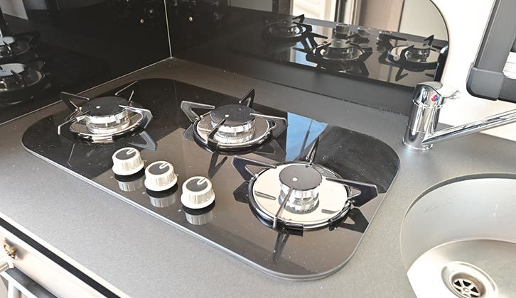 The kitchen has a three burner gas hob and combined oven/grill