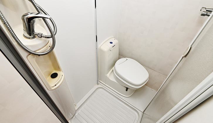 Corner washroom with electric-flush toilet and combined shower with folding doors