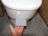 For a Dometic toilet, begin by pulling out the lever that opens the toilet blade