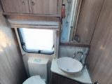 The compact washroom, with a toilet and salad-bowl handbasin