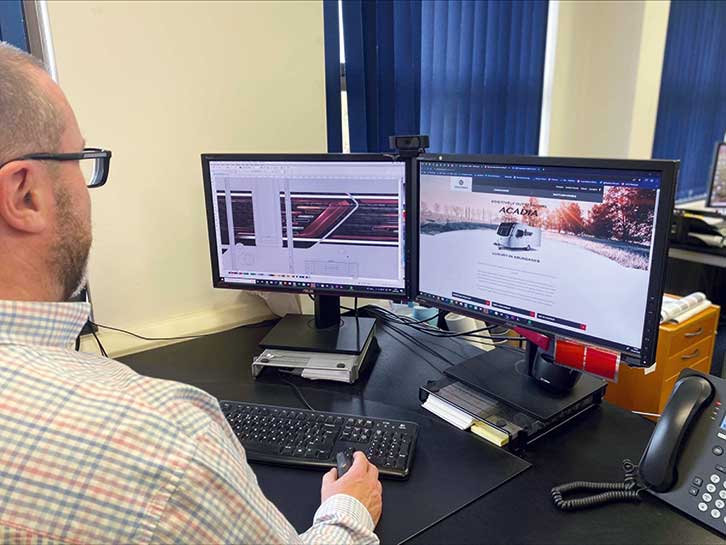A member of the CGI design team works on graphics for the Coachman Acadia