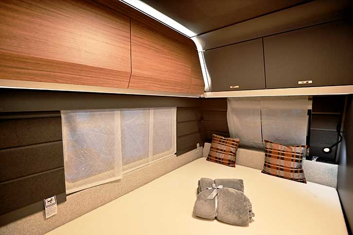 Fixed double bed and overhead lockers