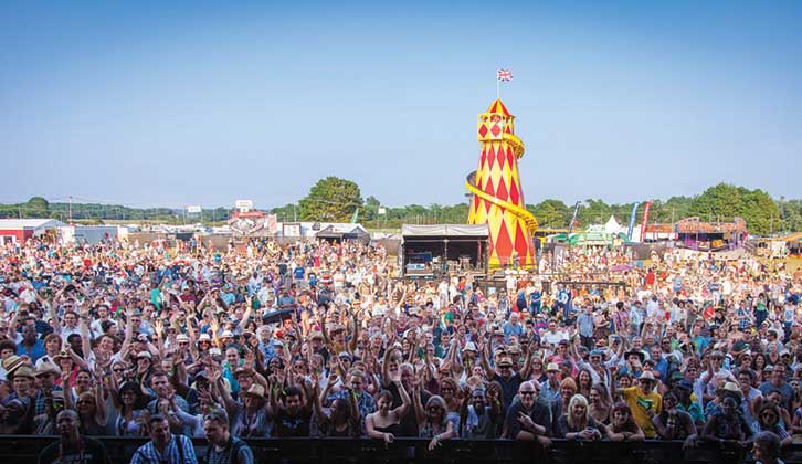 Busy music festival with helter skelter in background