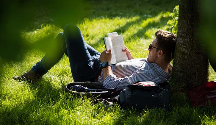 Man reading under tree