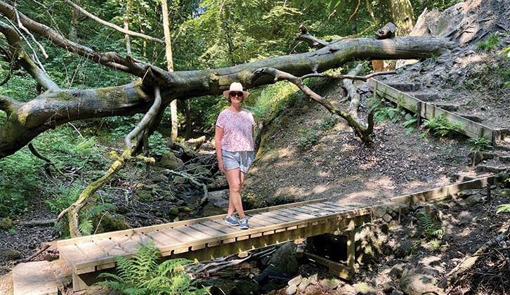 Woman on fallen tree trunk