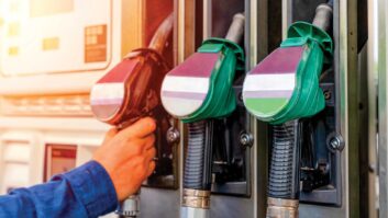 Hand reaching for pumps at a fuel station