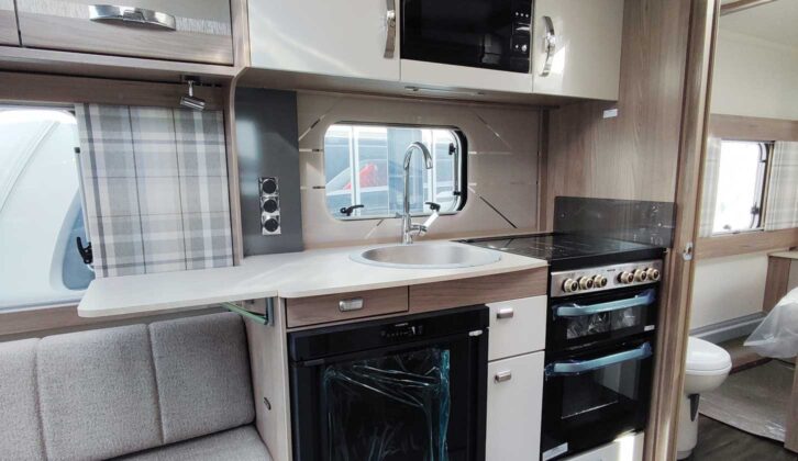 The kitchen area, with a dual-fuel four-burner hob, fridge, sink and microwave