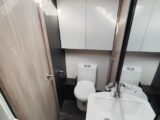 Washroom includes toilet under a cupboard