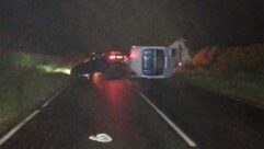 Crashed car and flipped over caravan