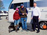 Sally and Andrew by their Adria caravan with their dog and the dealer