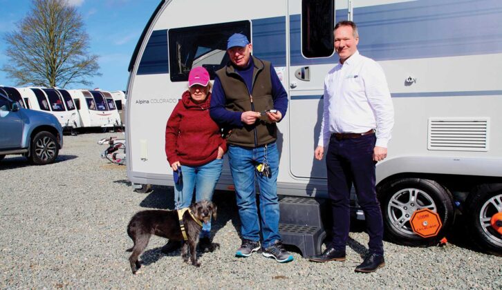 Sally and Andrew by their Adria caravan with their dog and the dealer