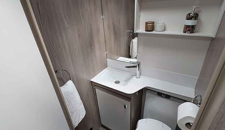 The washroom with a handbasin, shelving and a mirror