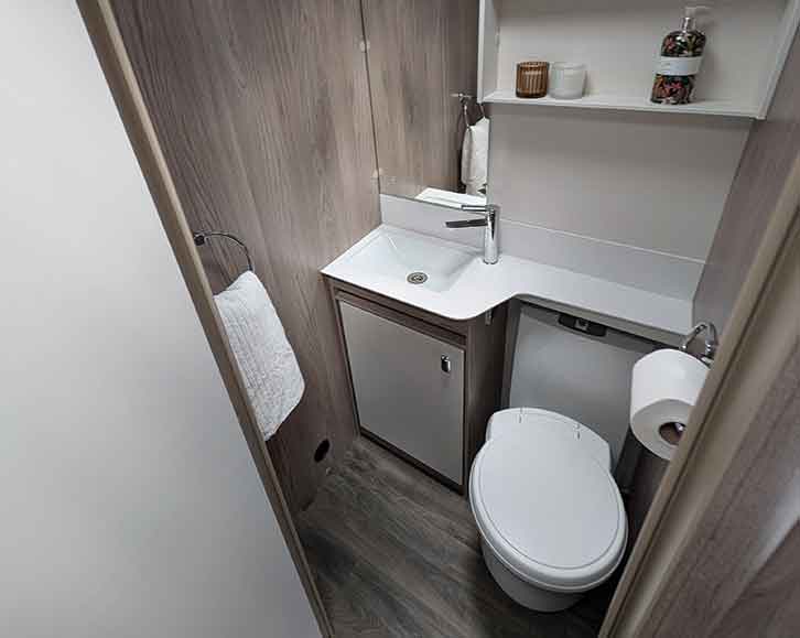 Main washroom has a mirror above the handbasin and plenty of shelving