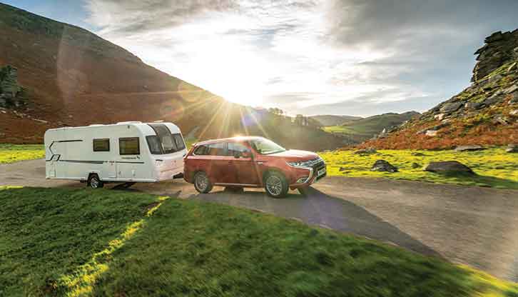 A caravan being towed along a narrow road