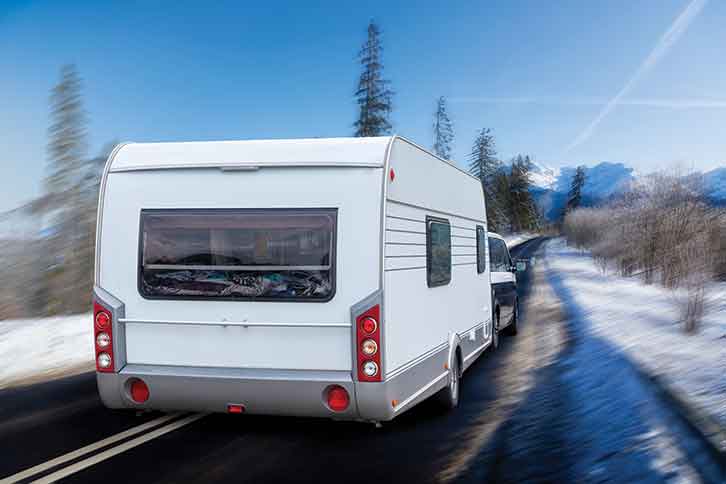 A caravan being towed in wintery conditions