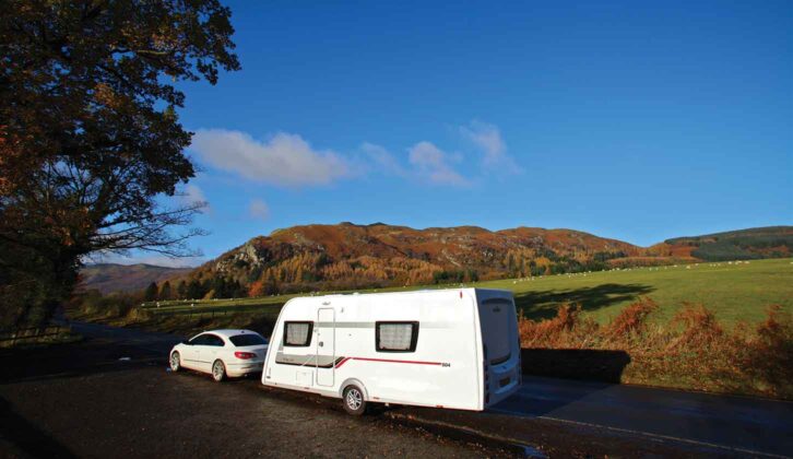 A car towing a caravan in winter