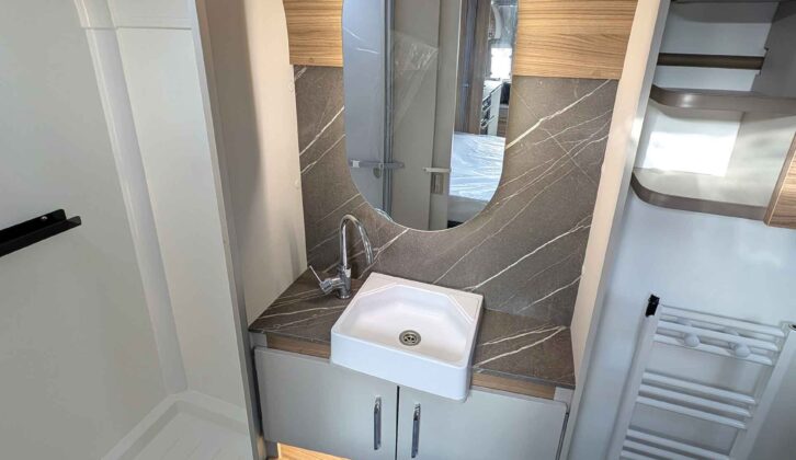 The lozenge-shaped mirror behind the handbasin
