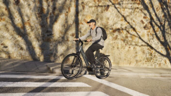 A man riding a Tenways AGO Air through an urban area in the sunshine