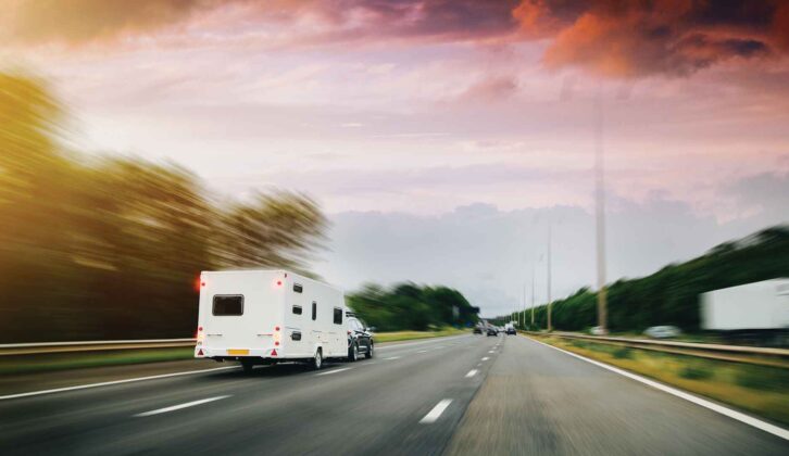 A car towing a caravan on a main road