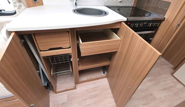 The stainless steel sink and kitchen cupboards