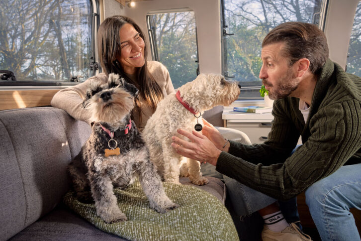 A couple and two dogs in the lounge of a new Bailey Phoenix Black Edition