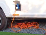 A coiled hook-up lead under a caravan