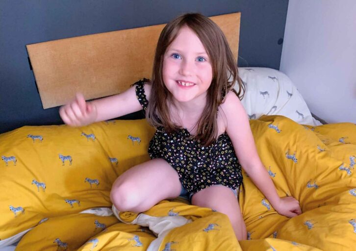A child sitting on a yellow duvet
