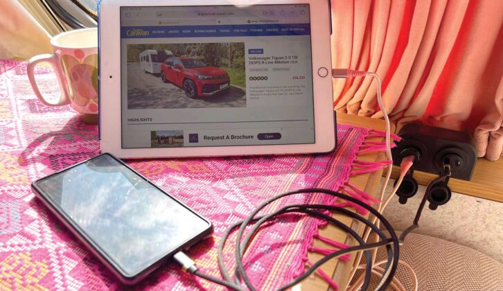 A mobile phone and an iPad charging in a caravan