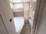 The fixed double bed, the bunk beds, and overhead lockers at the rear of the van