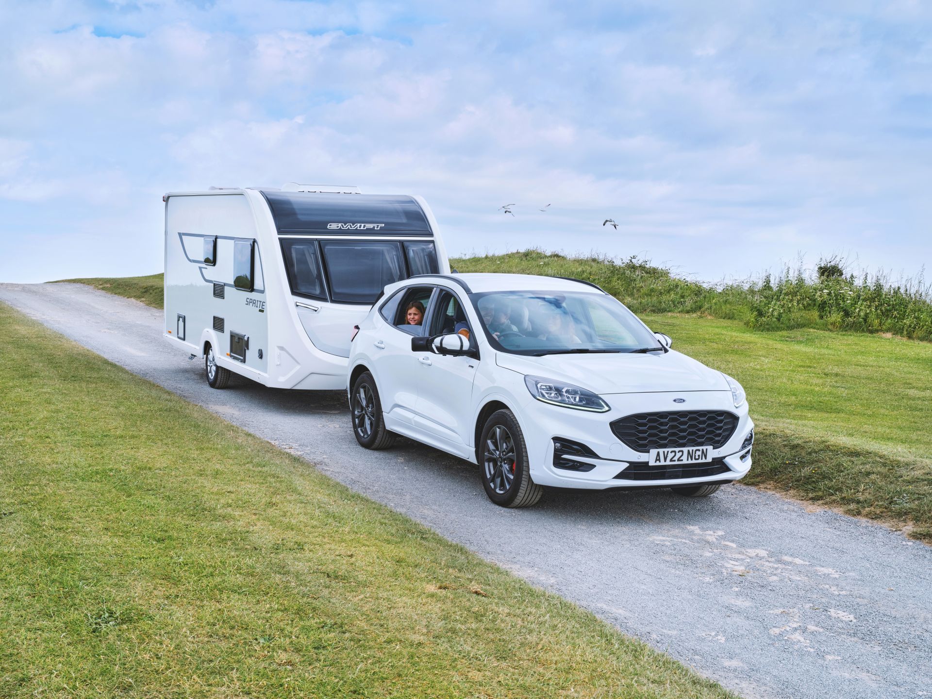 A tow car pulling a Swift Sprite caravan