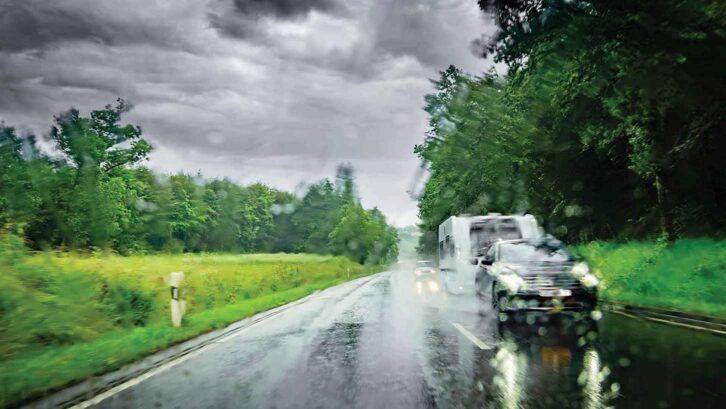 A car towing a caravan in the rain