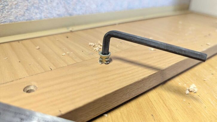 Driving a threaded nut into the drawer front