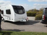 A man manoeuvring his caravan up to his tow car