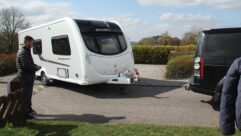 A man manoeuvring his caravan up to his tow car