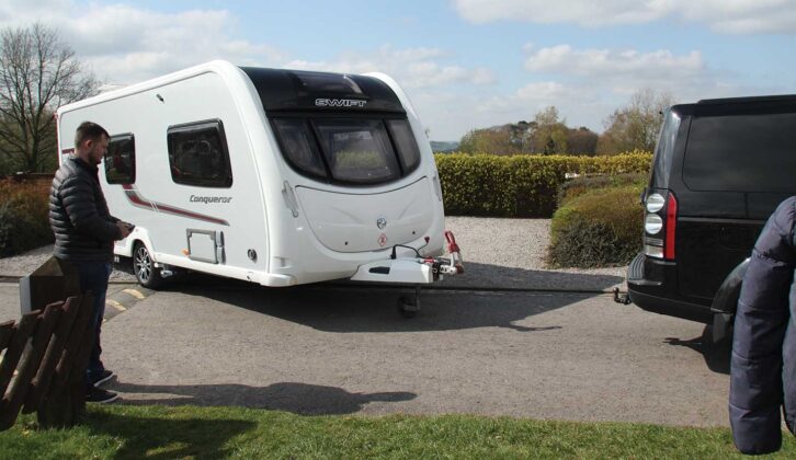 A man manoeuvring his caravan up to his tow car