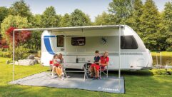 A family relaxing under a Fiamma wind-out awning