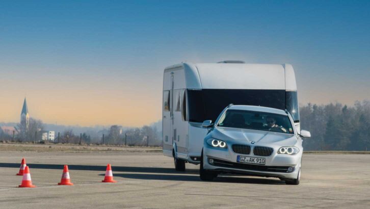 A car turning with a caravan hitched up