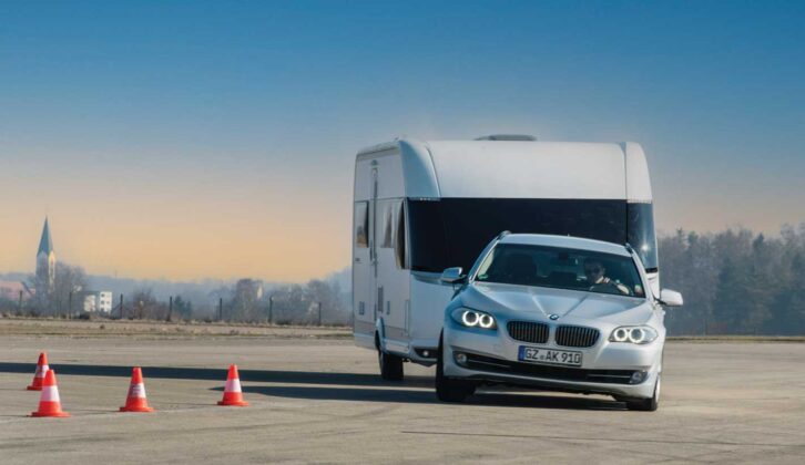 A car turning with a caravan hitched up