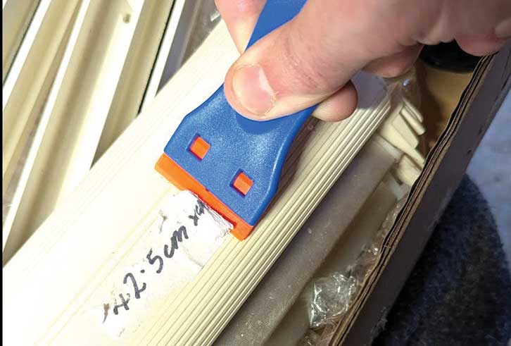 Using a scraper to remove the price tag