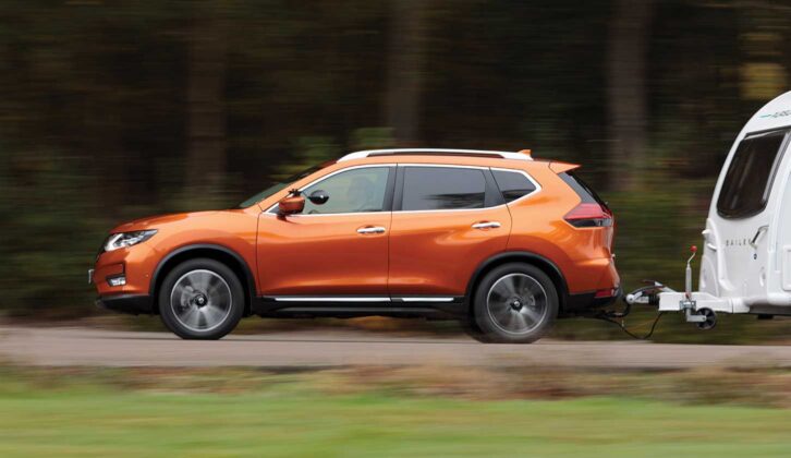 A side photo of the X-Trail towing a caravan