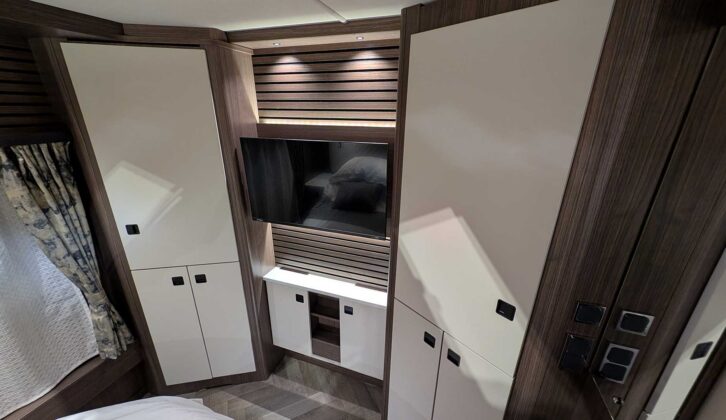 A TV mounted opposite the island bed