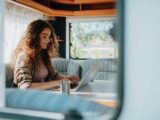 A woman on a laptop in a caravan