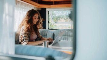 A woman on a laptop in a caravan
