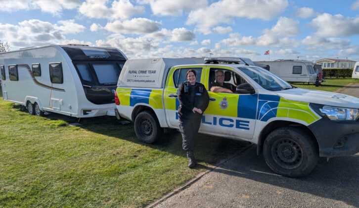 A police car and officers by the caravan
