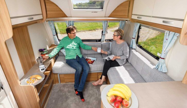 A couple sitting in the lounge of a caravan