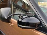 A towing mirror in place on a car