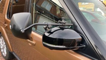 A towing mirror in place on a car
